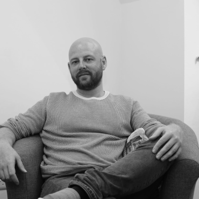 Joseph Archer, seated and relaxed in a therapy room armchair